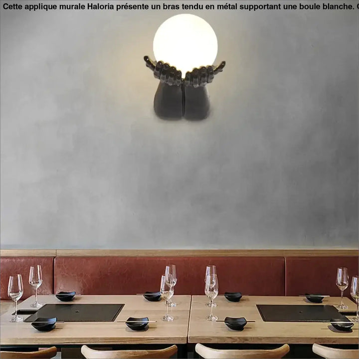 Applique murale avec brand tendu tenant une boule blanche


