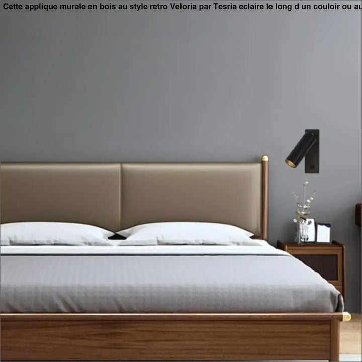 Applique murale avec une main en bois style retro installée long d’un couloir et lit beige avec cadre en bois et accents dorés