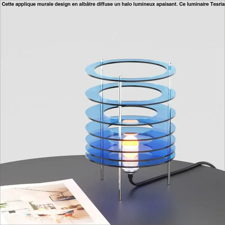 Lampe de table krona avec anneaux superposés en acrylique bleu translucide et supports métalliques chrome pour décoration intérieure et table design