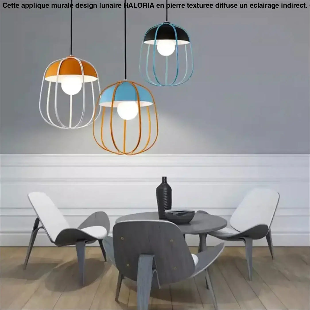 Trois suspension luminaire caldera avec cadres en fil orange bleu et noir au-dessus d’une table à manger
