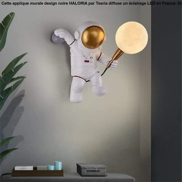 Applique murale design noire avec astronaute blanc casque doré et lumière lune dorée haloria