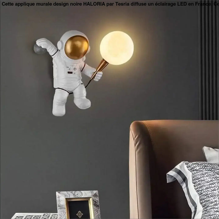 Applique murale design blanche en forme d’astronaute avec visière dorée tenant une lampe sphérique lumineuse haloria