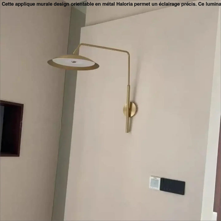 Applique murale design en métal finition laiton avec bras courbé et abat-jour circulaire plat haloria