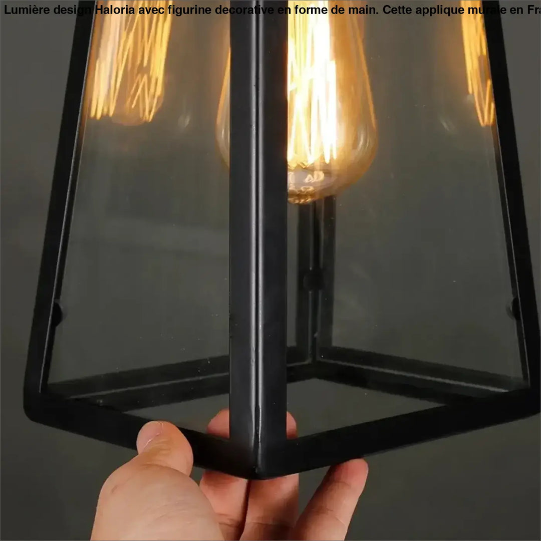 Black metal-framed suspension luminaire jardi with clear glass panels and a glowing filament bulb luminaire rétro-industriel