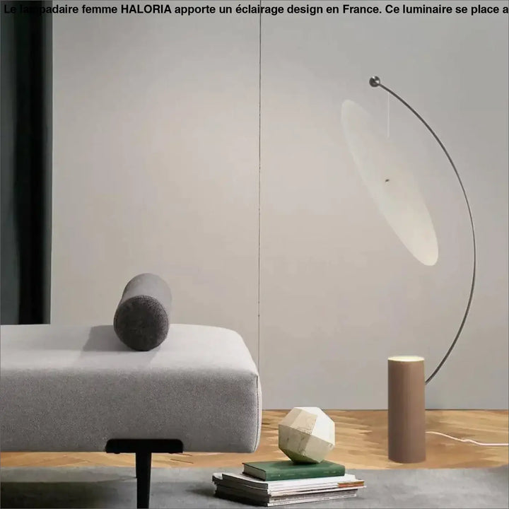 Femme lampadaire haloria avec structure en métal noir incurvée et abat-jour blanc translucide côté d’un canapé