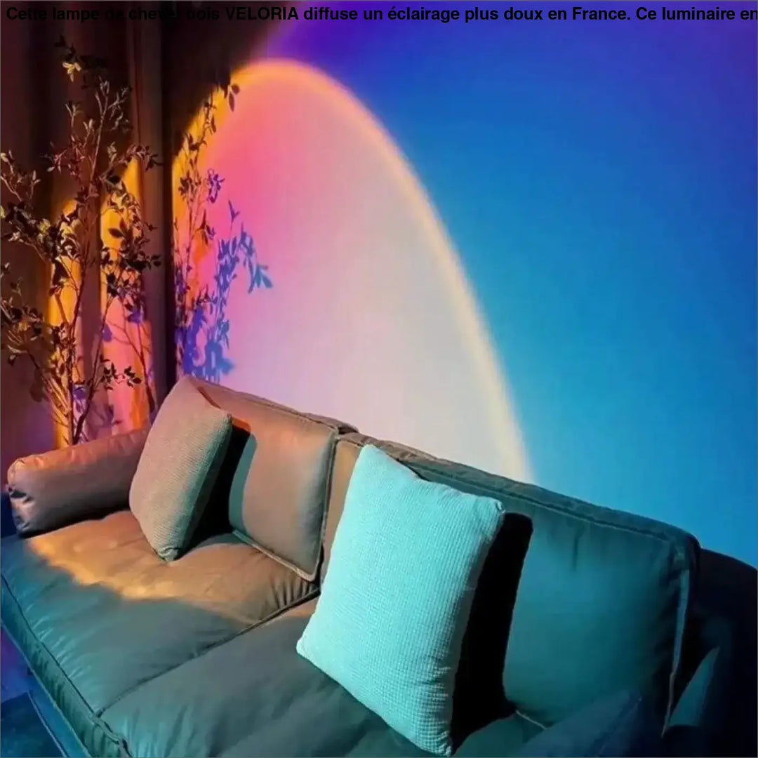 Lampe de chevet bois veloria éclairant un canapé en velours bleu sarcelle avec coussins texturés et projection lumineuse colorée