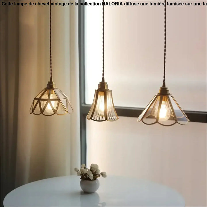 Suspension luminaire aureL avec trois lampes en métal doré et verre cannelé au-dessus d’une table blanche