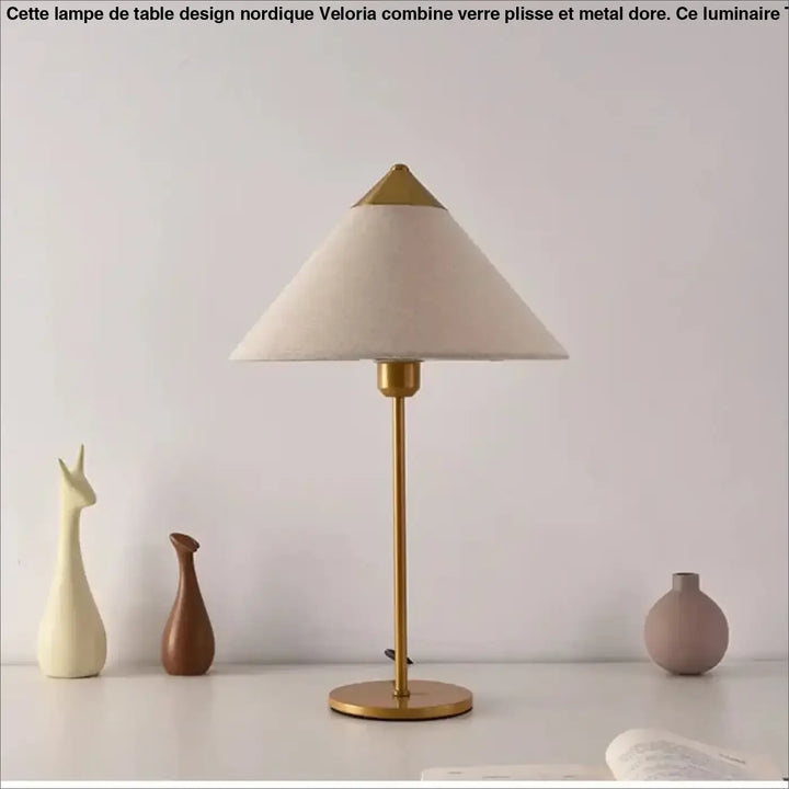 Lampe de table rine avec abat-jour en tissu crème et base fine en métal finition laiton pour une ambiance chic moderne