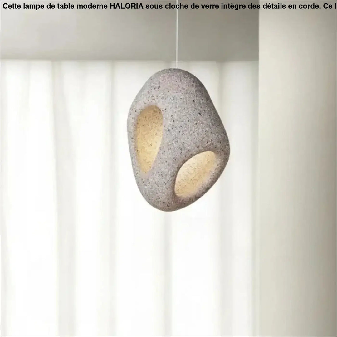 Suspension luminaire cavia en pierre grise tachetée avec deux découpes ovales laissant filtrer une lumière chaude