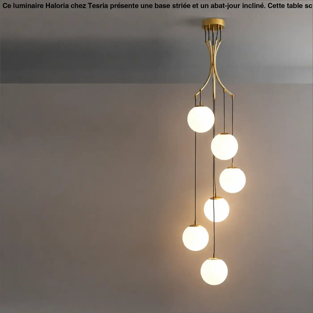 Suspension luminaire umami en laiton avec cinq globes en verre blanc disposés en cascade et lumineux