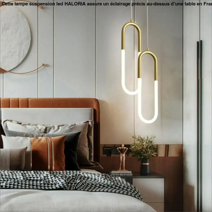 Lampe suspension led haloria avec tubes en verre blanc illuminés et structure u en métal doré suspendue au-dessus du lit
