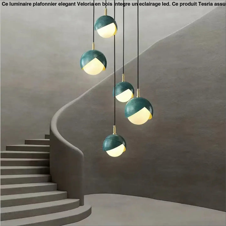 Luminaire plafonnier élégant en bois avec éclairage led, suspensions teal et or au design sphérique moderne au-dessus d’un escalier