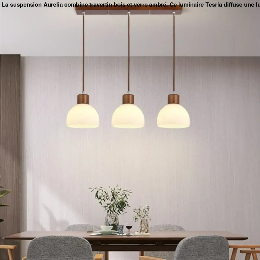Suspension bois travertin verre ambre design elegant aurelia avec trois lampes suspendues en verre ambre au-dessus d’une table