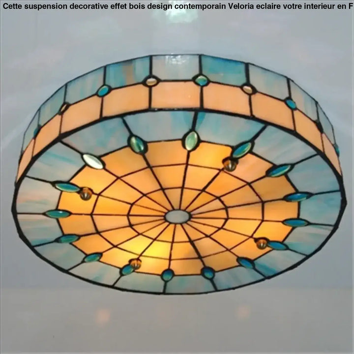 Suspension decorative effet bois veloria avec un plafond lumineux en verre teinté orange, bleu et accents verts ovals