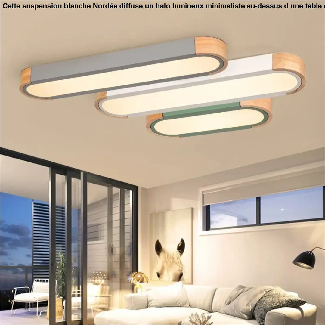 Suspension design blanche halo lumineux minimaliste avec trois panneaux rectangulaires blancs, gris et verts en bois naturel, au-dessus d’une table ou d’un coin salon