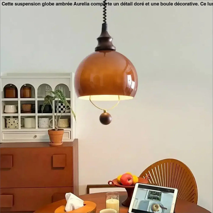 Suspension globe ambrée avec détail doré et boule décorative

