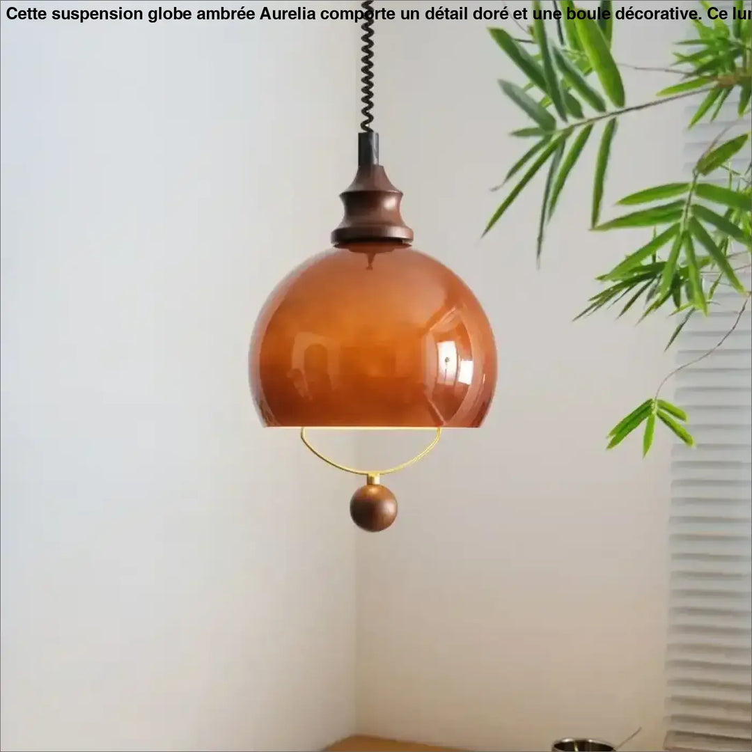 Suspension globe ambrée avec détail doré et boule décorative

