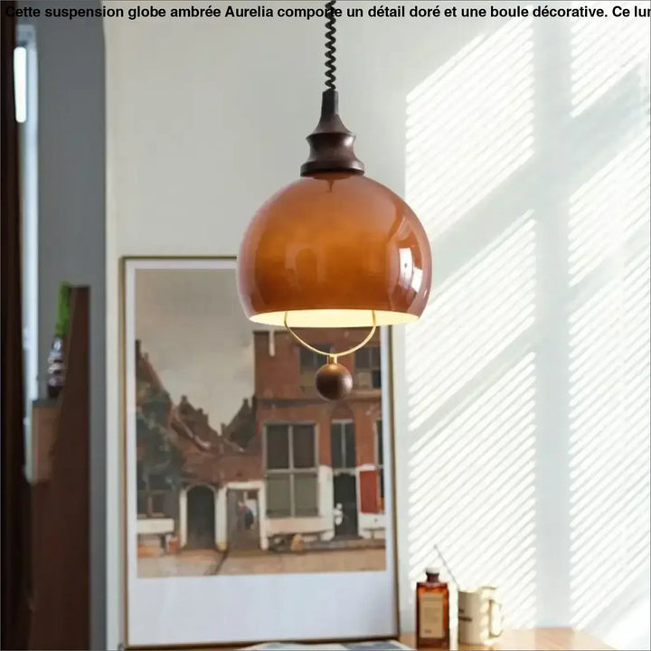 Suspension globe ambrée avec détail doré et boule décorative

