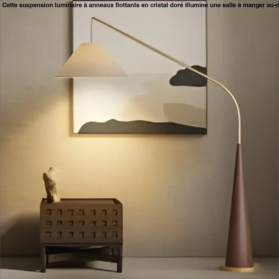 Lampadaire arvika avec pied métallique courbé argenté et base conique ton chaud pour salon ou chambre