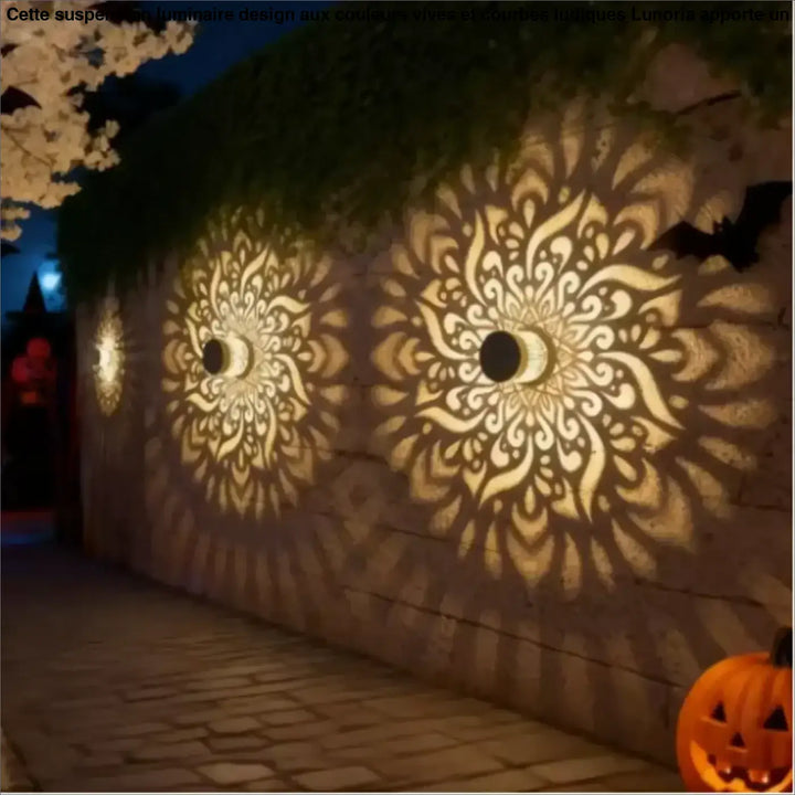 Luminaire extérieur qualih lampe murale orne en métal doré avec mandalas découpés et lumière chaude sur mur en pierre