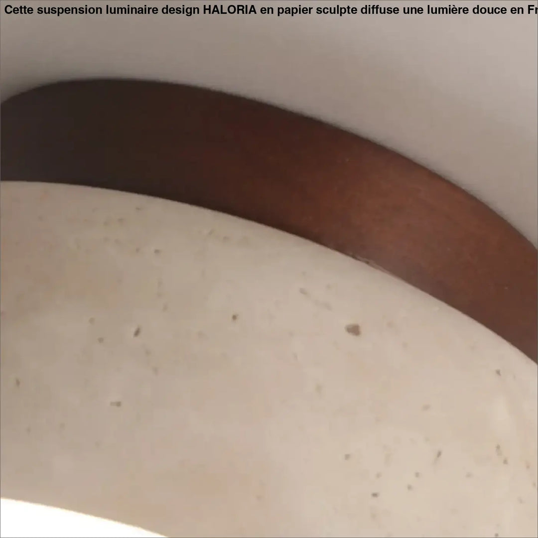 Sangle de ceinture en cuir brun foncé lisse pour suspension luminaire design en papier sculpté haloria sur surface beige