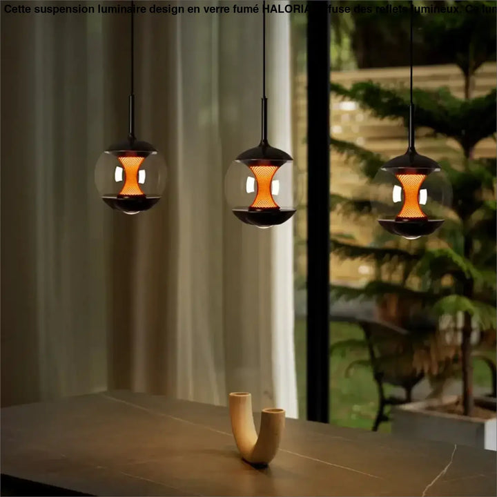 Suspension luminaire nexus avec trois luminaires suspendus noirs en métal et globes en verre clair à luminosité variable