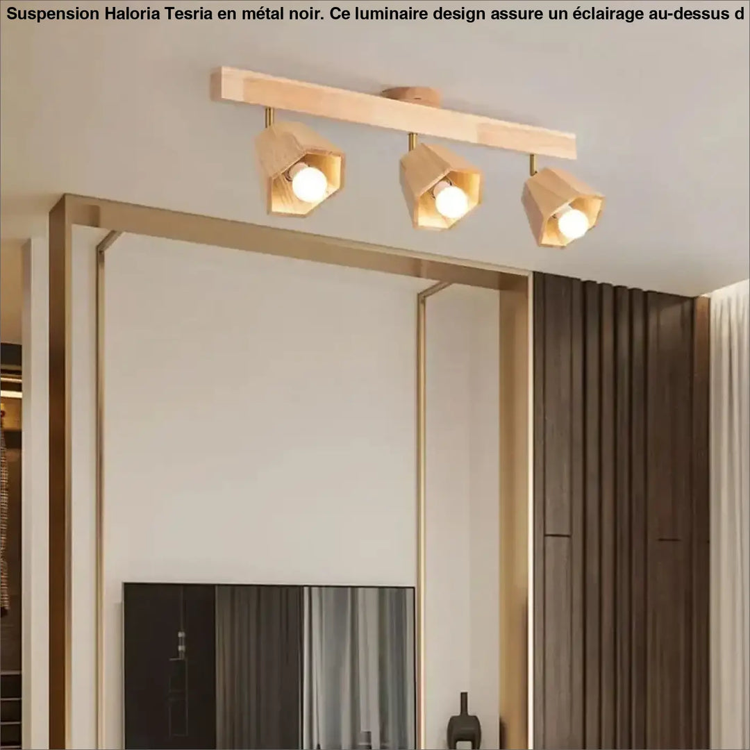 Luminaire design moderne noir en metal avec trois lampes hexagonales au-dessus d’une table en bois clair