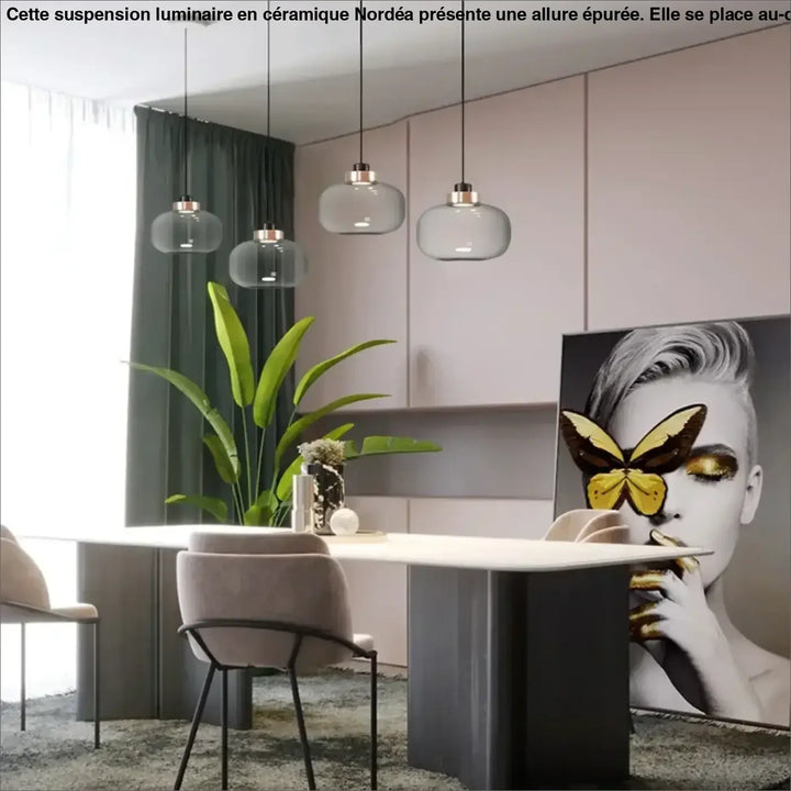 Suspension luminaire mistral avec verre gris fumé et accents métalliques suspendue au-dessus d’une table à manger