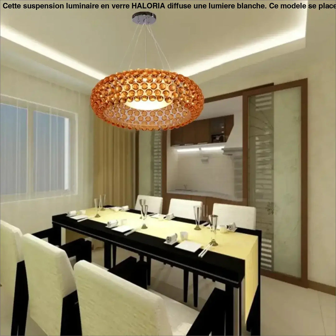 Suspension luminaire en verre orange avec lumière blanche au-dessus d’une table design circulaire moderne haloria