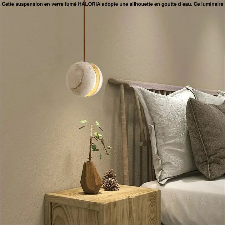 Suspension luminaire kreto sphérique minimaliste en béton texturé off-white avec halo doré chaleureux et travertin aux lignes élégantes