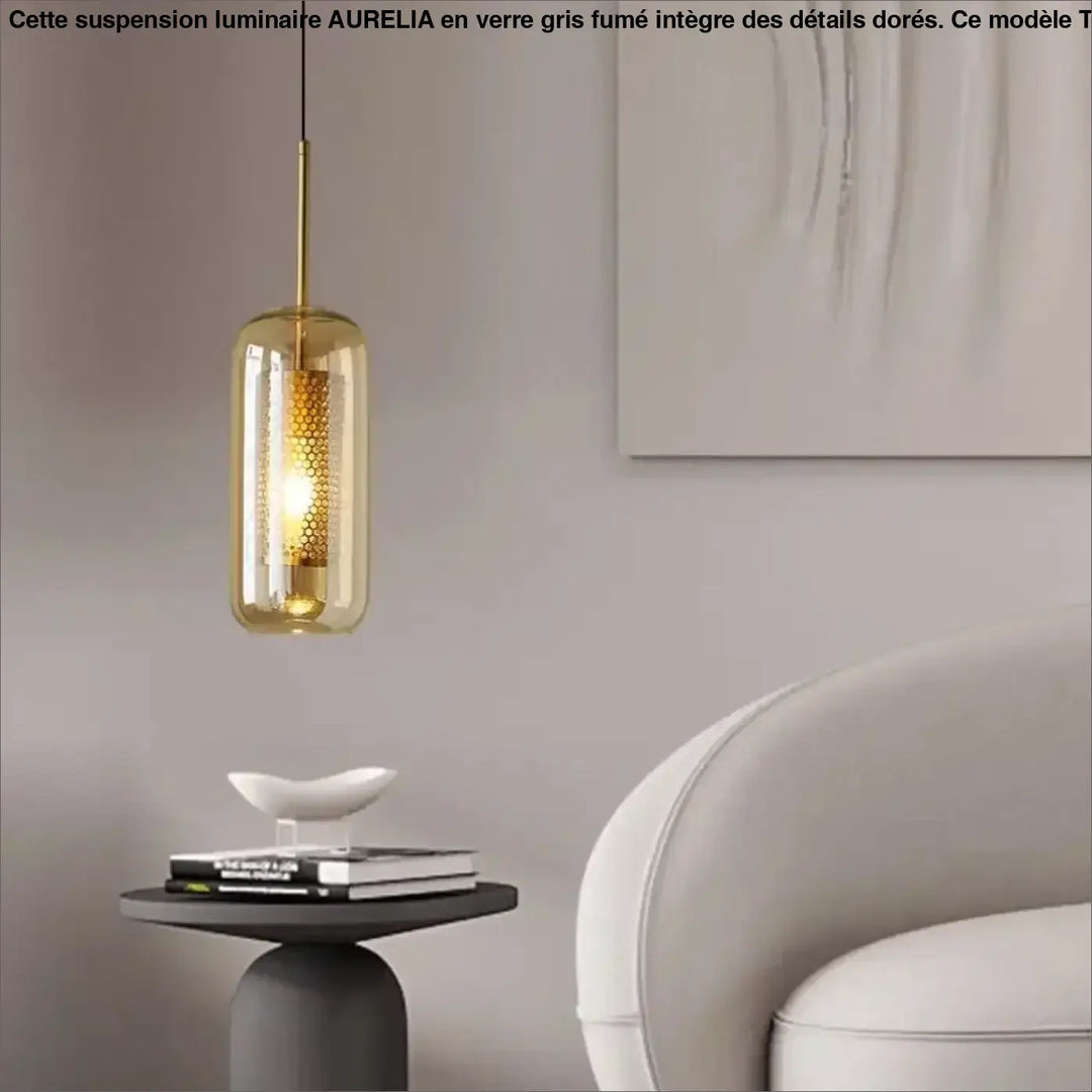 Suspension luminaire eloria en verre transparent aux teintes ambre avec cadre métallique doré et motif alvéolé