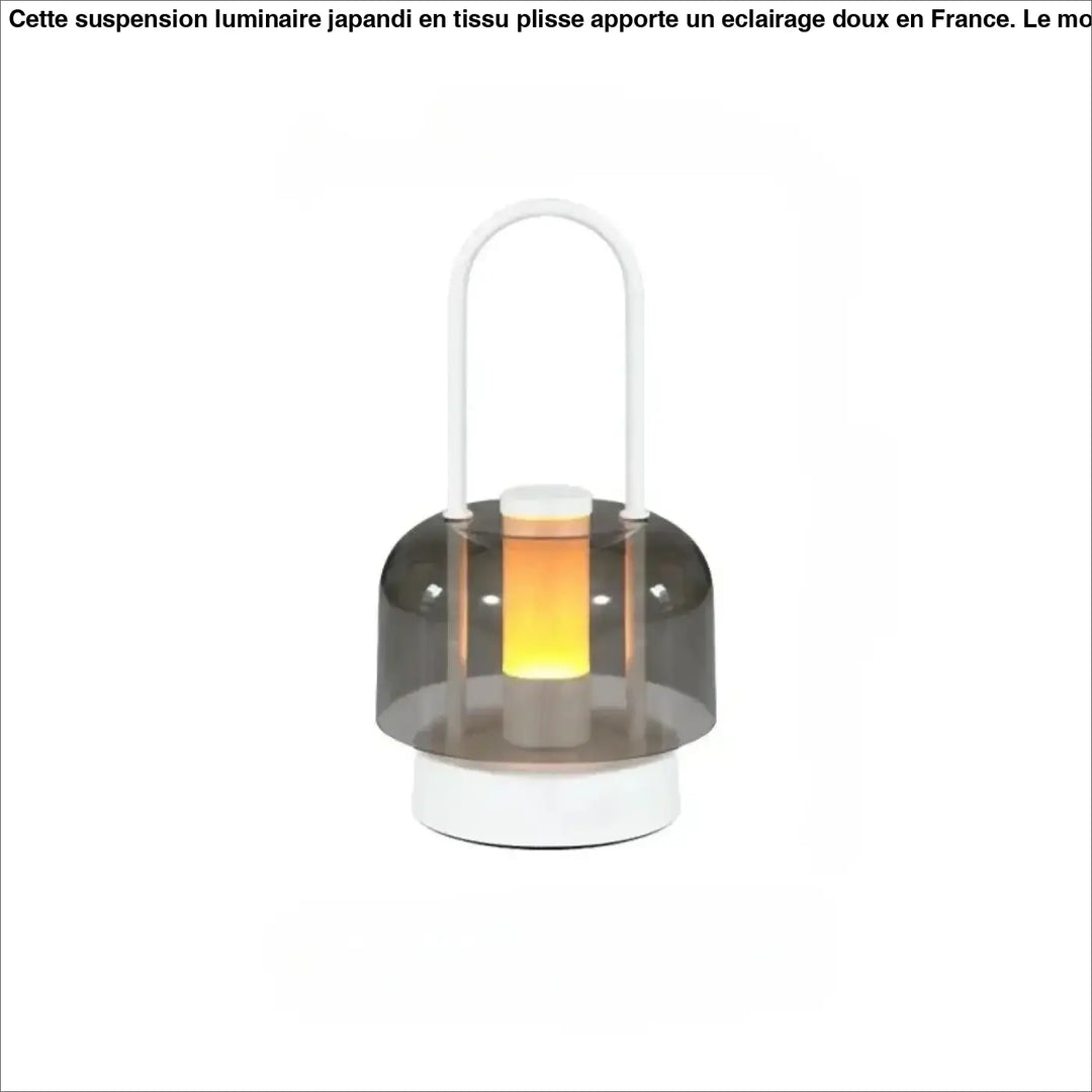 Lampe de table Cristo avec dôme gris translucide et base blanche émettant une douce lumière orange, idéal comme night light
