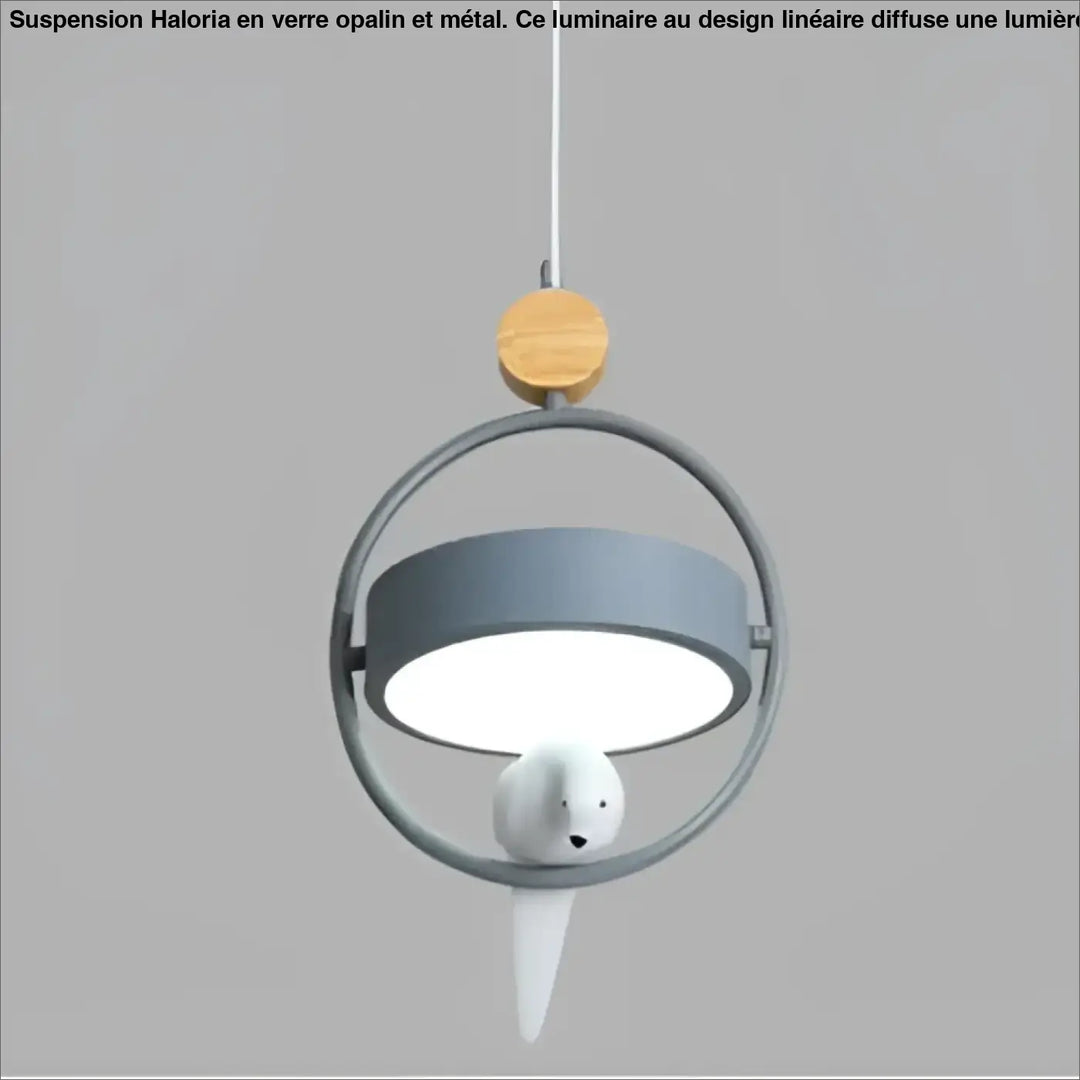 Suspension luminaire lineaire en verre opalin avec cadre métallique circulaire, abat-jour gris et oiseau céramique blanc au-dessus d’une table