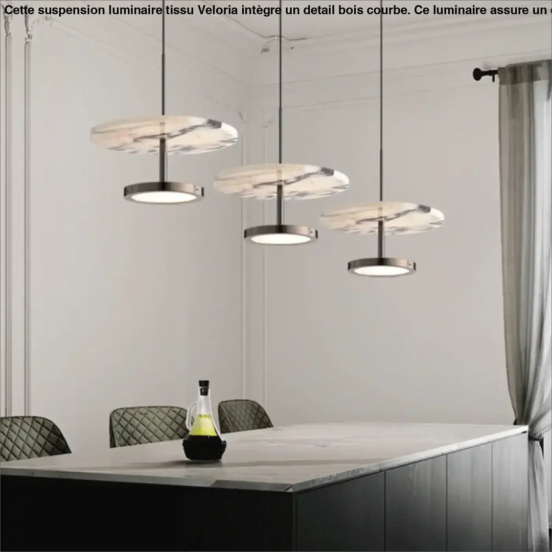 Trois suspension luminaire tissu avec detail bois courbe en marbre et métal suspendues au-dessus d’une table à manger
