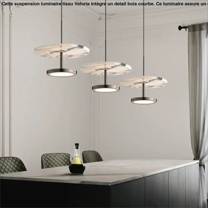 Trois suspension luminaire tissu avec detail bois courbe en marbre et métal suspendues au-dessus d’une table à manger