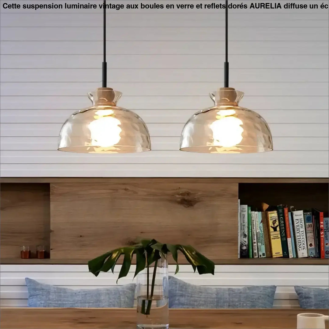 Suspension luminaire tukai avec deux abat-jours en verre texturé ton chaud suspendus au-dessus d’une table en bois