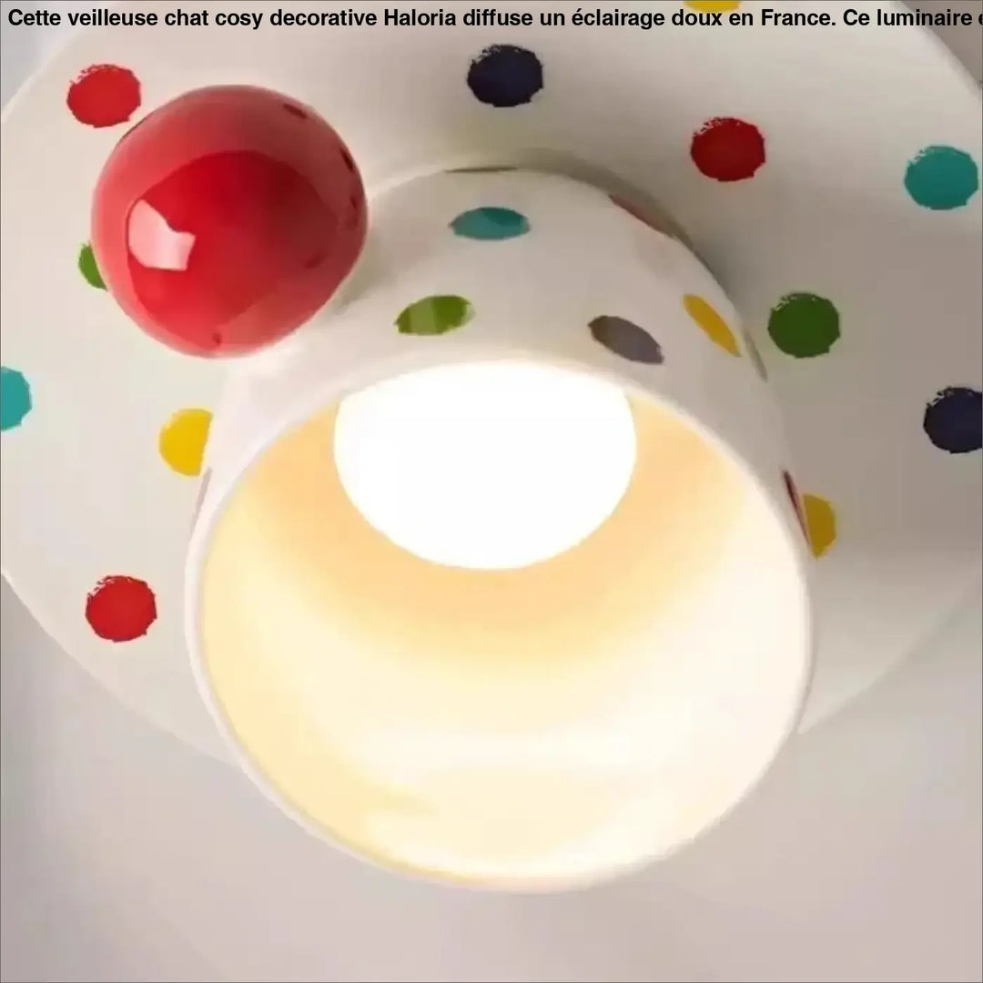 Luminaire plafonnier en céramique blanche avec tasse à pois colorés et accent sphérique rouge qui donne envie