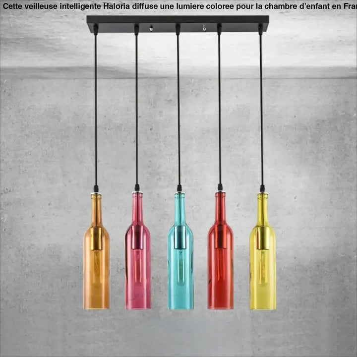 Suspension luminaire aria avec cinq bouteilles colorées en verre amber, rose, teal, rouge et jaune suspendues sur barre métal noir